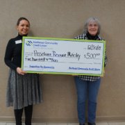 Velda Sizemore, NCCU Member Service Specialist, presents ARM Executive Director Faye Ingram with a donation of $500 for Assistance and Resource Ministries’ programs